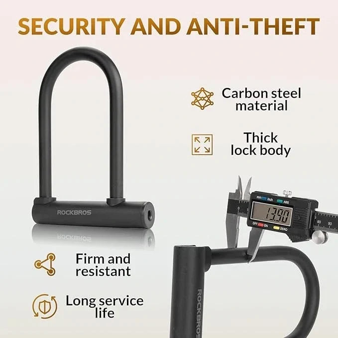 Black Rockbros carbon steel U-lock shown on a light beige background with promotional text and feature callouts, including 'Security and Anti-Theft,' 'Carbon steel material,' 'Thick lock body,' 'Firm and resistant,' and 'Long service life.' A caliper is shown measuring the lock body in the lower right.