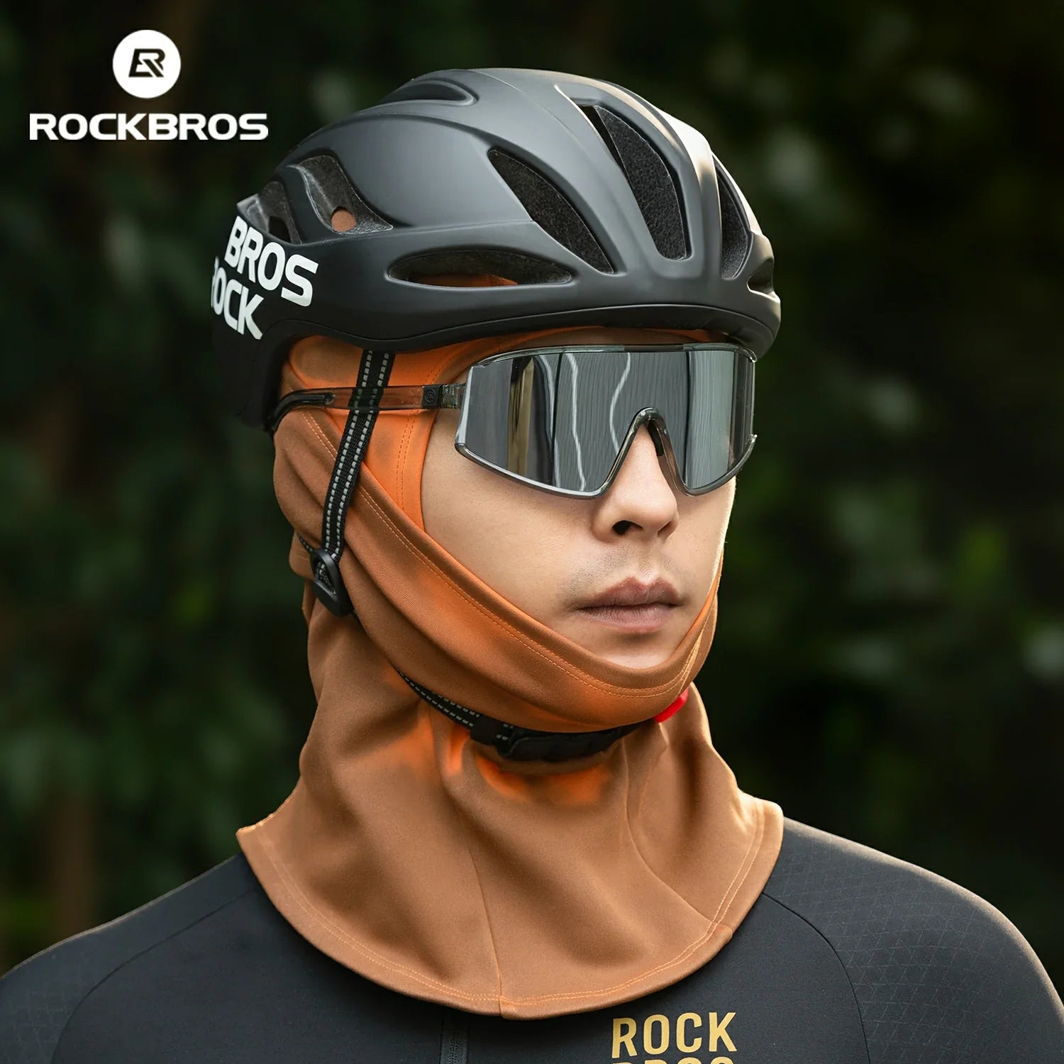Person wearing a RockBros helmet and sunglasses with a blurred green background #color_Brown