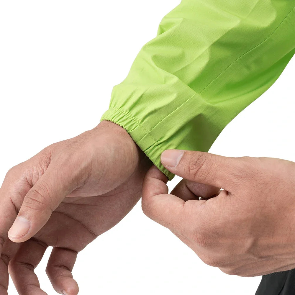 Close-up of a person's hands adjusting the elasticated wrist cuff of a bright lime green sleeve or jacket on a white background.