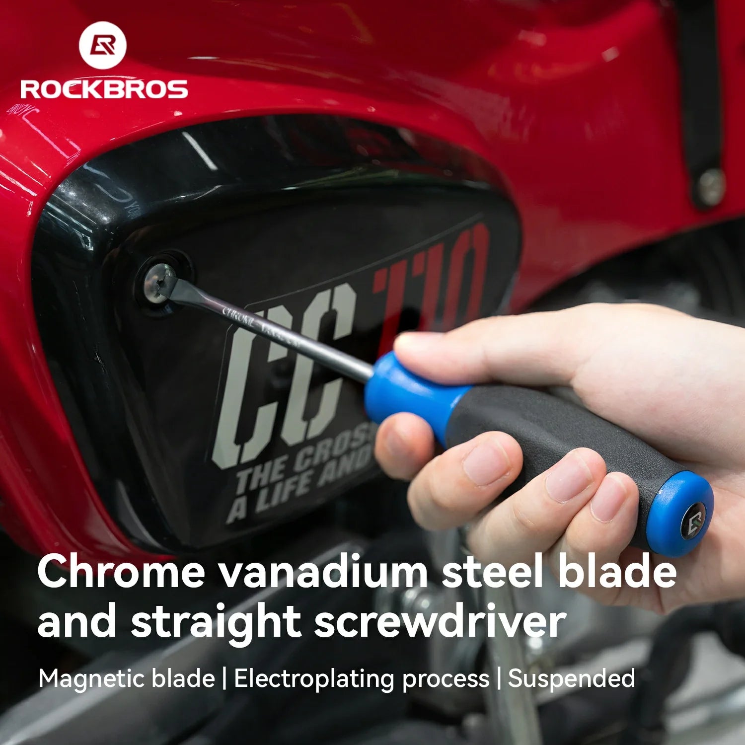 A hand using a Rockbros screwdriver to loosen a screw on a red motorcycle fender. The screwdriver has a chrome vanadium steel blade and a blue and black handle.