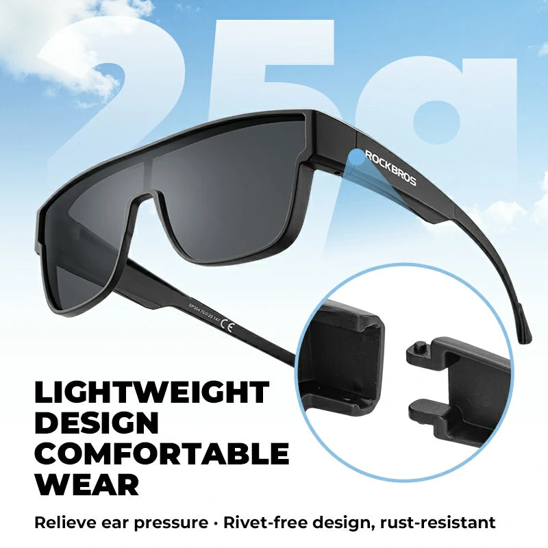 Black Rockros shield sunglasses with dark lenses, featuring a circular inset showing the lightweight adjustable ear clip design, set against a light blue sky background with promotional text.