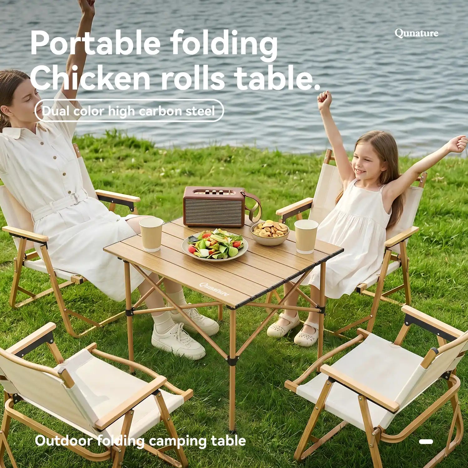 Two people sitting at a portable folding table outdoors by a body of water.
