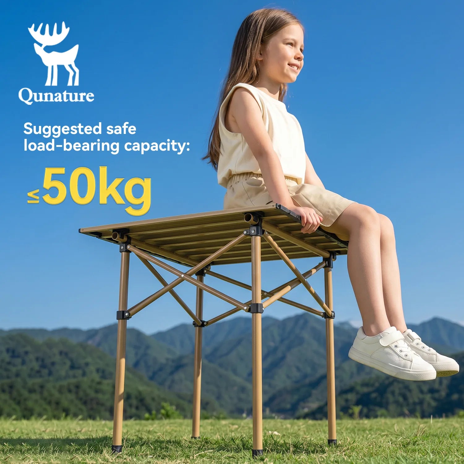 Child sitting on a portable folding table with Qunature branding and safety information against a mountainous background.