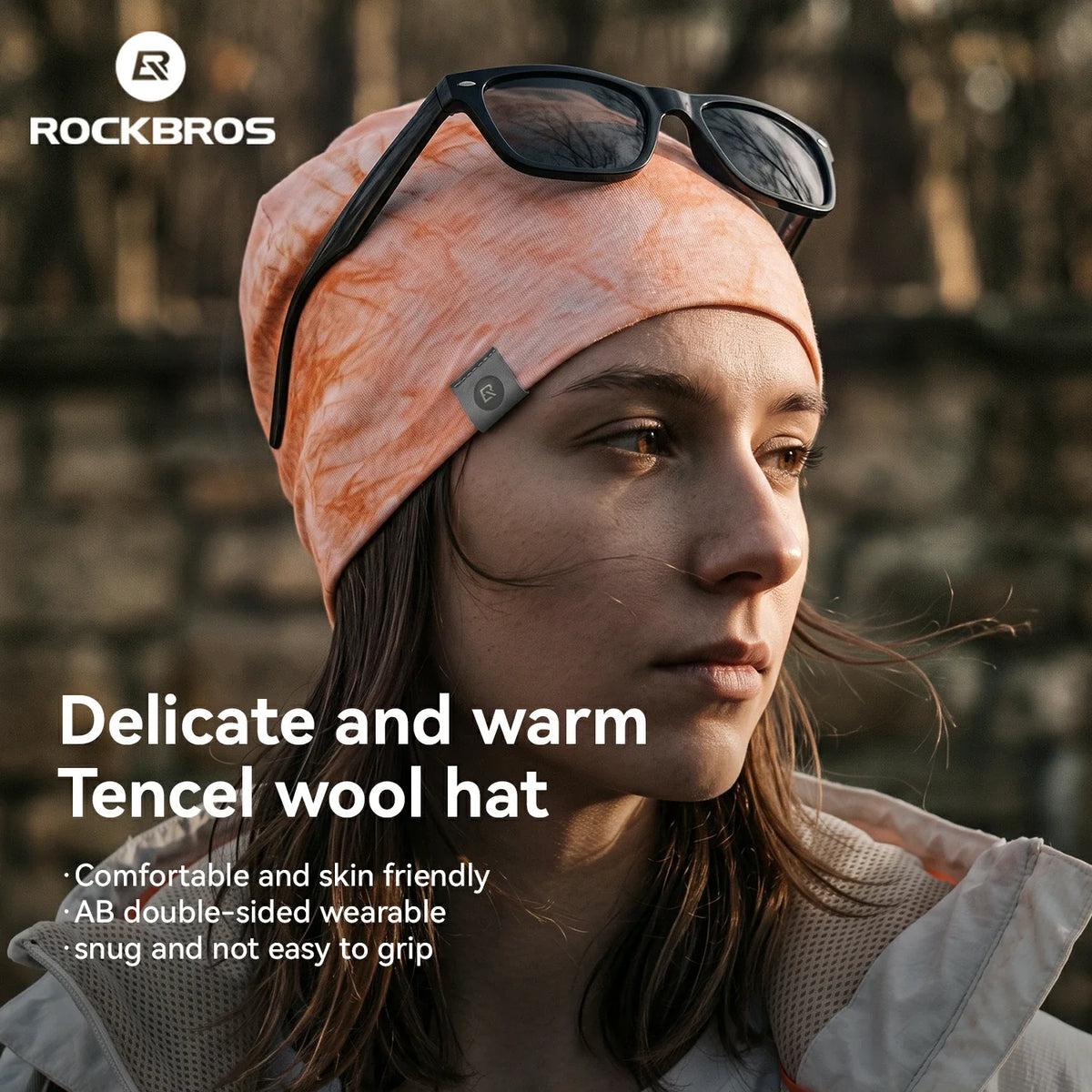 A woman wearing a peach and orange marbled Rockbros Tencel wool hat with black sunglasses on top of her head, set against a blurred outdoor background. Text overlays highlight the product's comfort and warmth.