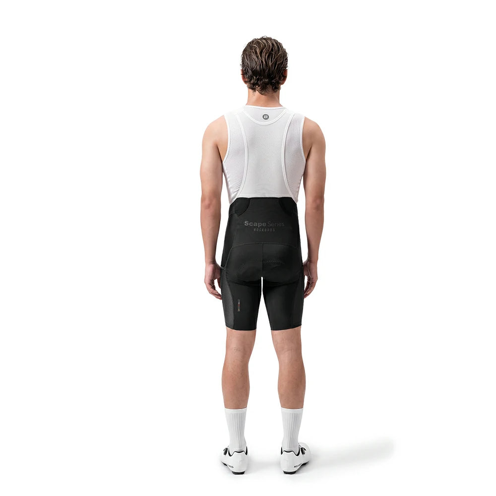 A man shown from the back wearing a white cycling bib jersey and black cycling shorts with a small white logo on the back waistband, standing against a plain white studio background.