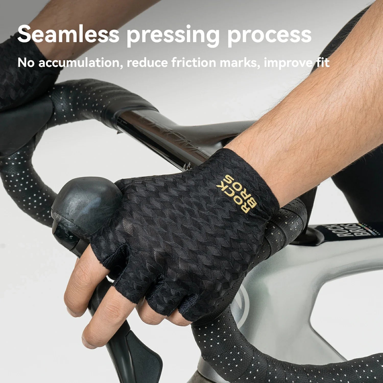 A close-up of a cyclist's hand wearing a black Rock Bros fingerless glove while gripping a road bike handlebar. White text at the top reads 'Seamless pressing process' with additional descriptive copy about reducing friction marks and improving fit.