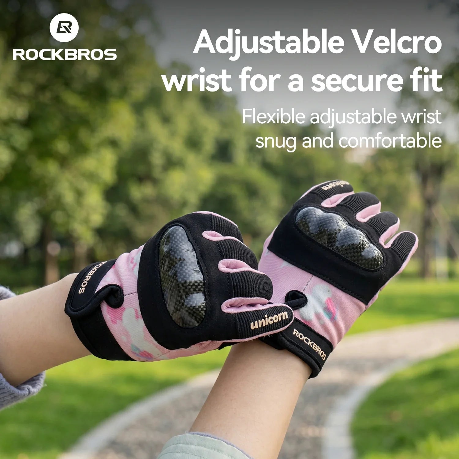Pink and black gloves with adjustable velcro wrist on a blurred outdoor background
