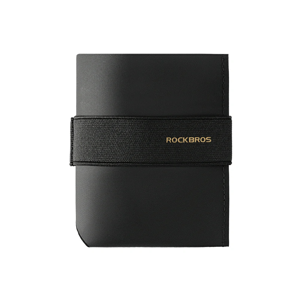 A black Rockbros slim wallet or card holder with a textured black elastic band across the front featuring the brand name in gold lettering, shown on a plain white background. #Color_Black