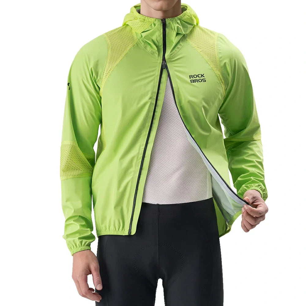 A man wearing a bright lime green RockBros lightweight hooded jacket over a white cycling jersey and black cycling shorts, shown against a plain white background.