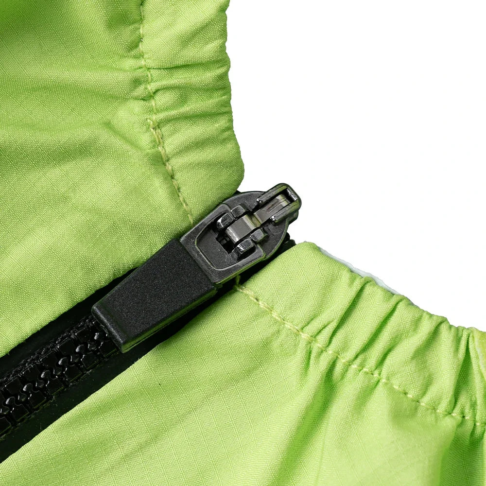 Close-up of a bright lime green fabric garment with a black zipper and dark gray pull tab, shown against a white background.