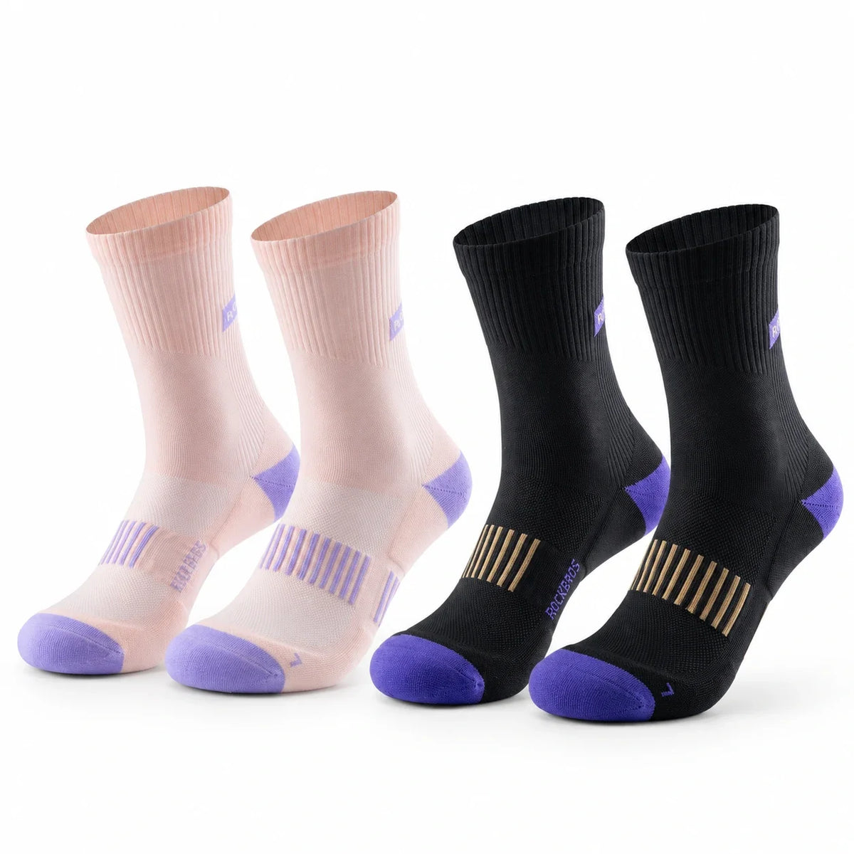 Four athletic crew socks arranged in two pairs on a white background: two light pink socks with purple toes and heels, and two black socks with purple toes and heels plus gold striped detailing. #Color_pink+balck