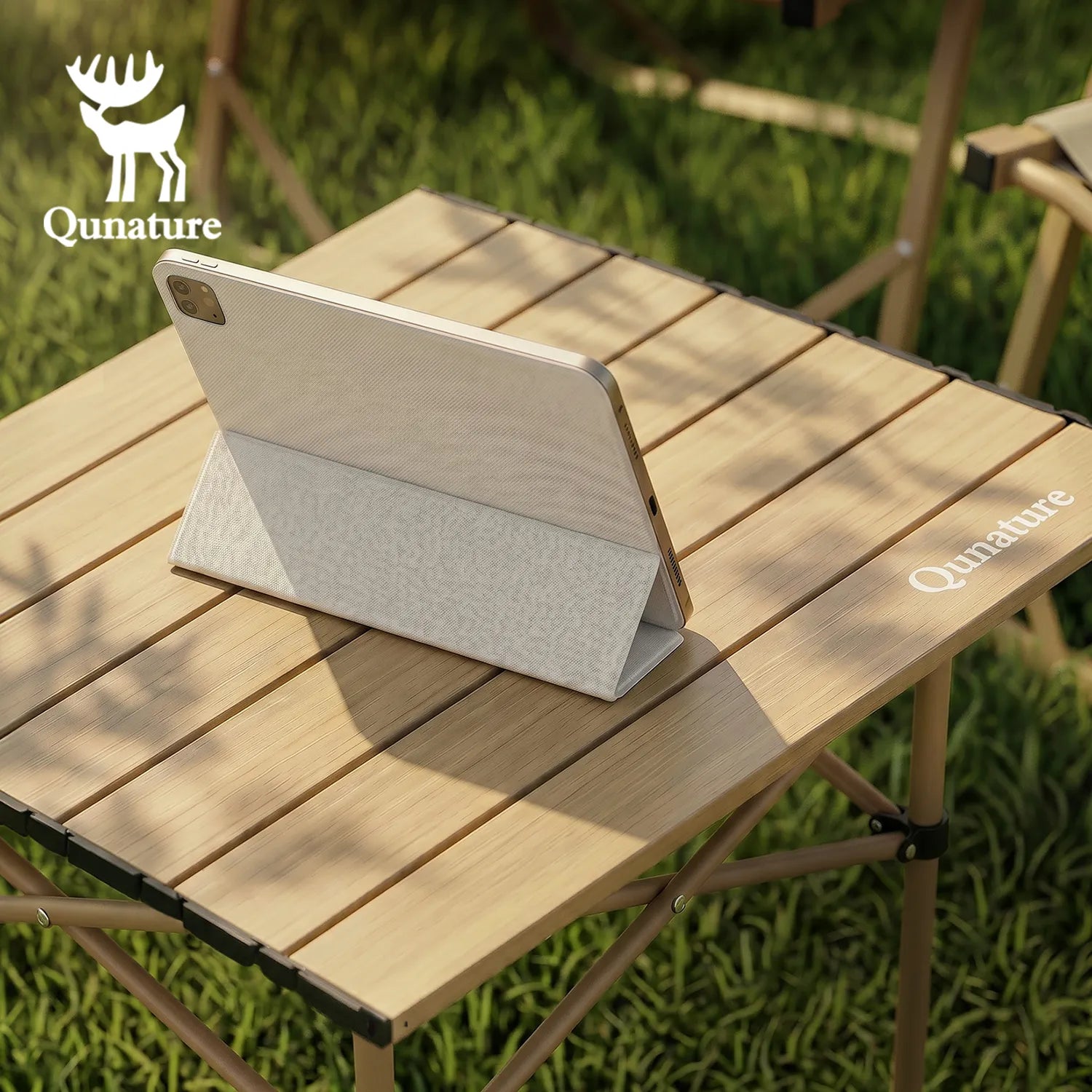 Tablet with a protective case on a wooden table outdoors, featuring the Qunature brand.
