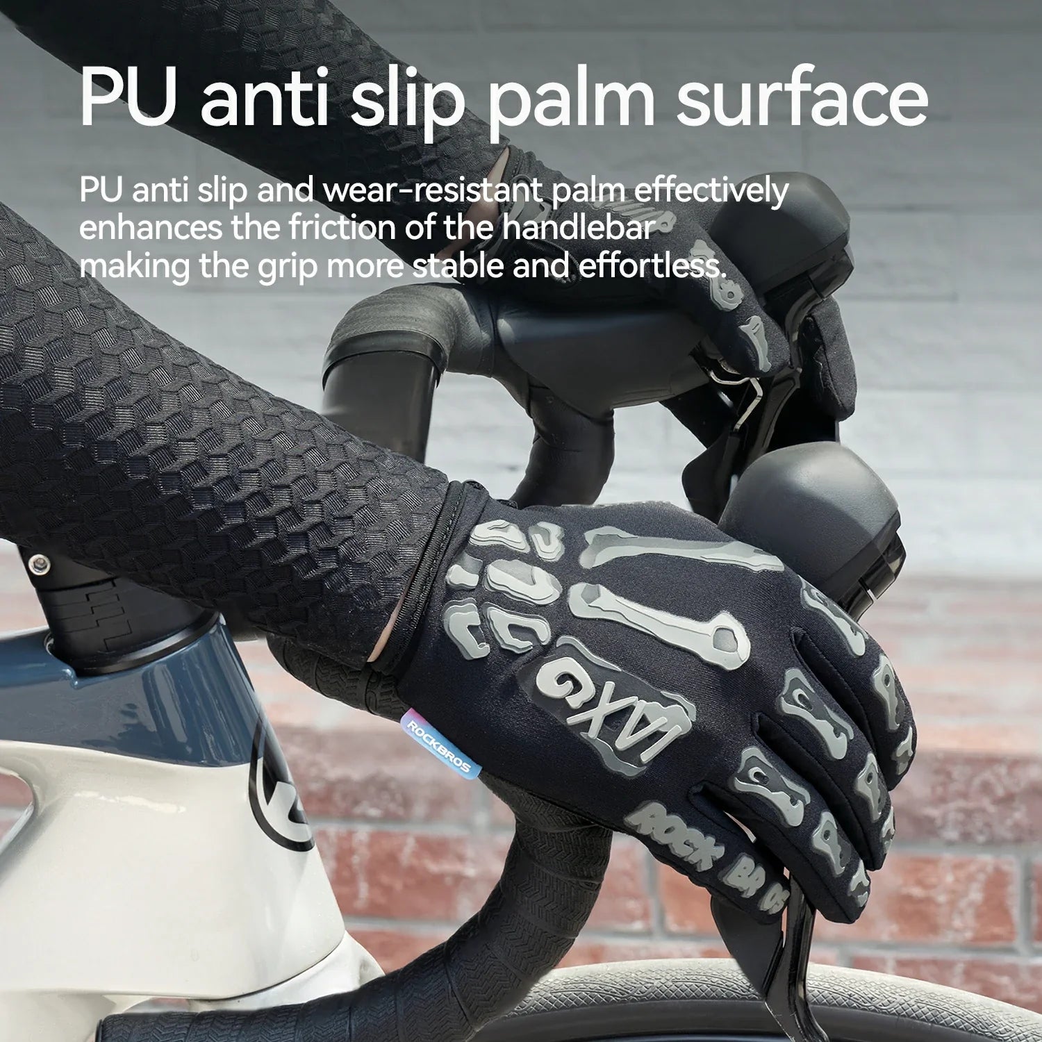 Black road cycling gloves with a white skeletal hand design, shown on a cyclist's hand gripping a road bike handlebar. White text at the top explains the PU anti slip palm surface.