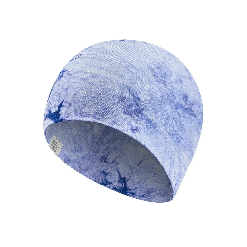 A fabric beanie hat featuring a blue and white tie-dye pattern, shown on a plain white background.  #Color_Blue