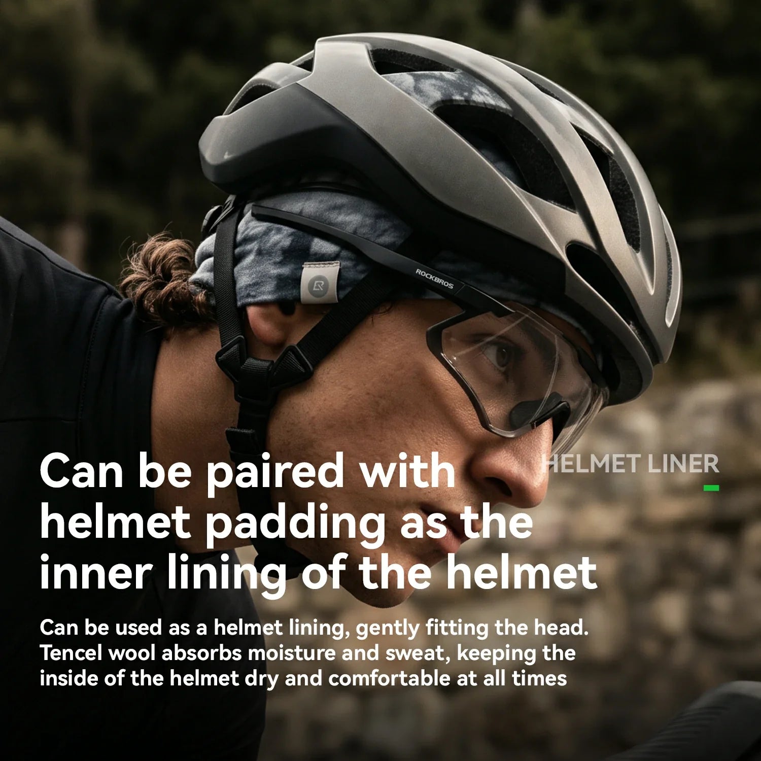Close-up of a person wearing a matte black bicycle helmet with a patterned headband and clear visor, outdoors. White text overlays explain that the helmet liner can be paired with helmet padding and used as a helmet lining. 