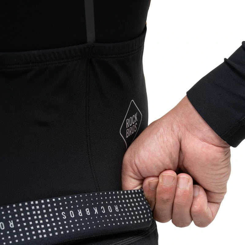 Person wearing a black jacket with 'Rock Bros' branding, holding a fist. #color_Brown